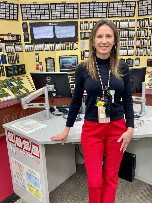 Amy Marshall standing inside a control room, leaning against a desk.