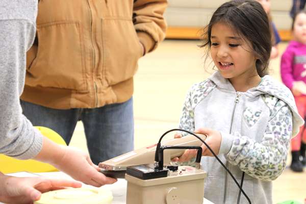 A participant in Kids Engineering Day learns about radioactivity using a radiation detector.